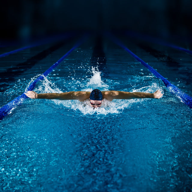 Mann schwimmt eine Bahn im Schwimmbecken